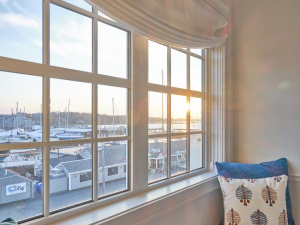 The view of the Newport Harbor at sunrise from a window in a Newport, RI, hotel room through a large window.