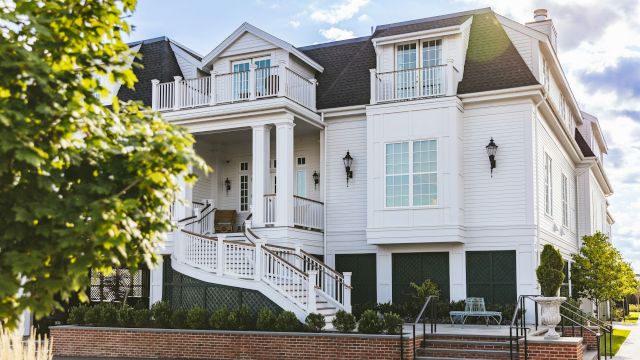 A large white house with a balcony and stairs